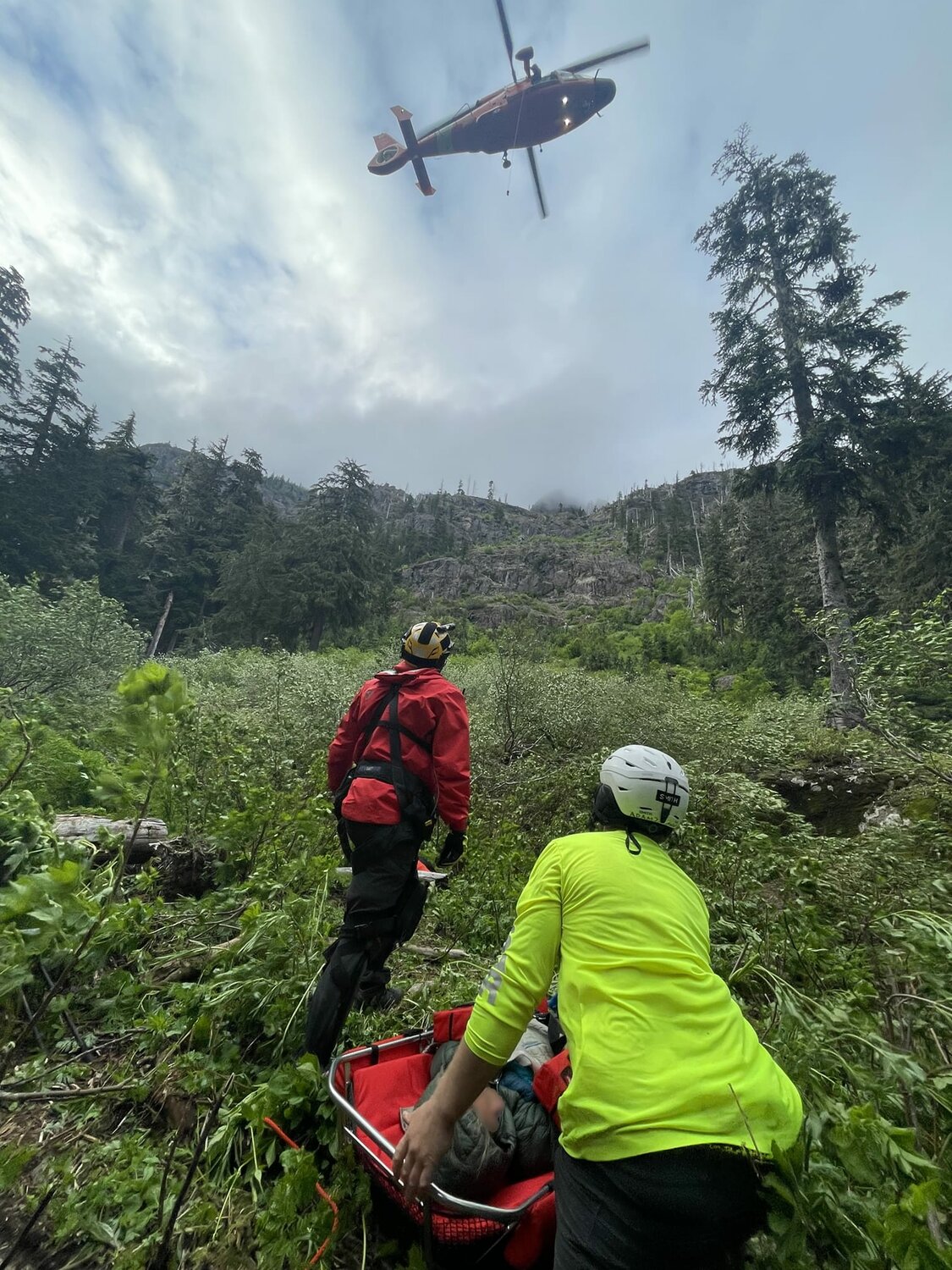JSAR responded to a distress call from a climbing party on the Brothers in July 2022. The climber was located above Brothers basecamp approximately seven miles from the trailhead in very rugged terrain. A U.S. Coast Guard rescue helicopter from Air Station Port Angeles Coast Guard was called in to extract the injured party. JSAR member Adam Boling shields the patient from debris as the hook comes down. Photo courtesy JSAR